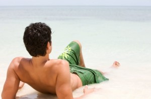 man laying on beach, for Dr. Hess plastic surgeon's blog in Fairfax VA