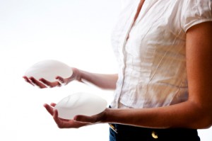 woman holding silicone breast implants safety