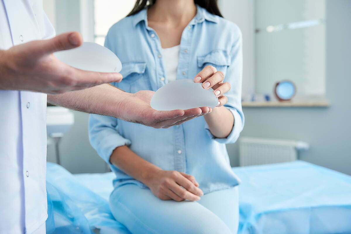 Woman and plastic surgeon comparing textured breast implants