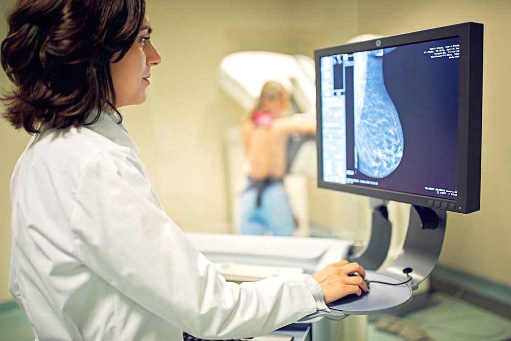 scientist at computer reviewing imaging scan of breast