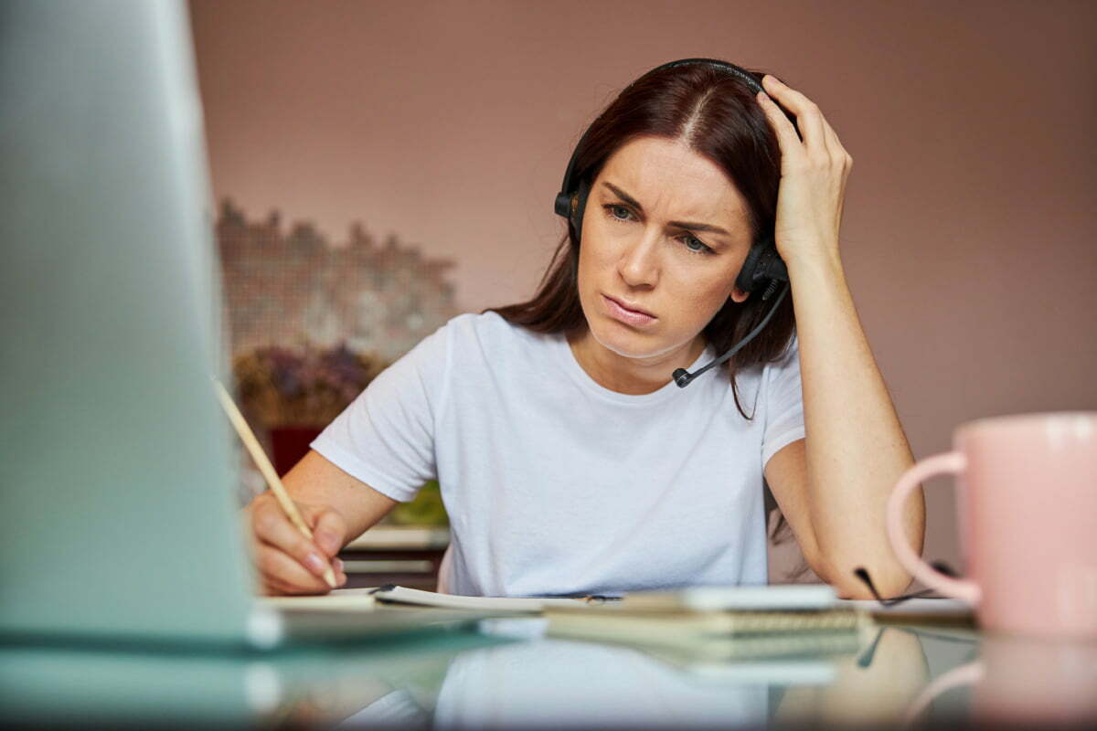 Woman in Zoom Meeting Frowns at Herself on Camera thanks to Zoom dysmorphia